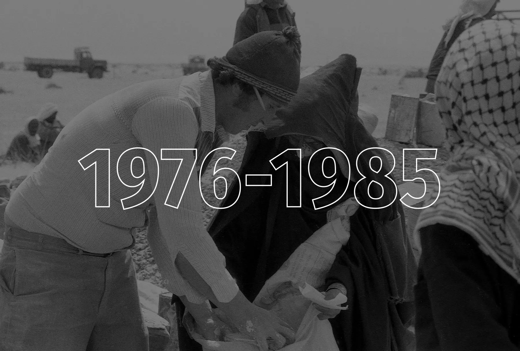 A black and white image of a man leaning over and pulling flour out of a food bag.
