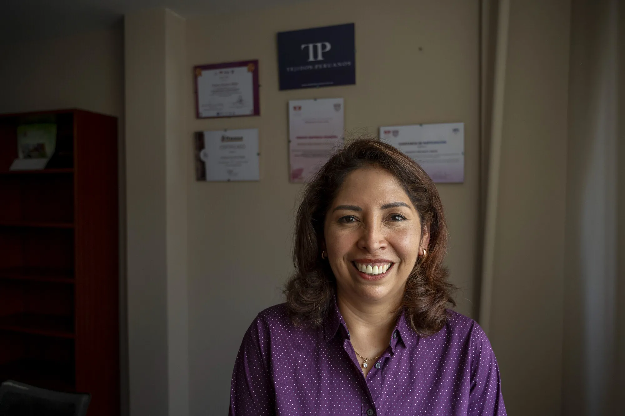 Indoor portrait of smiling woman, looking directly at camera.