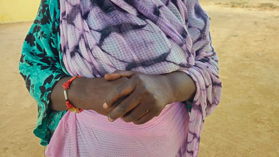 Woman holding her hands together in front of her.