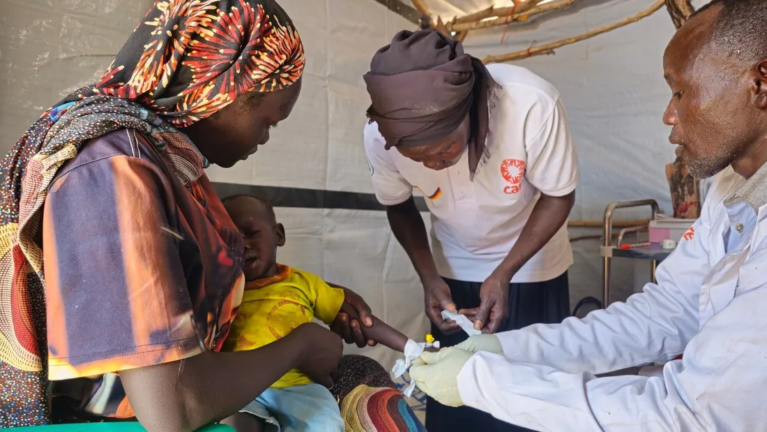 Healthcare workers helping young child.
