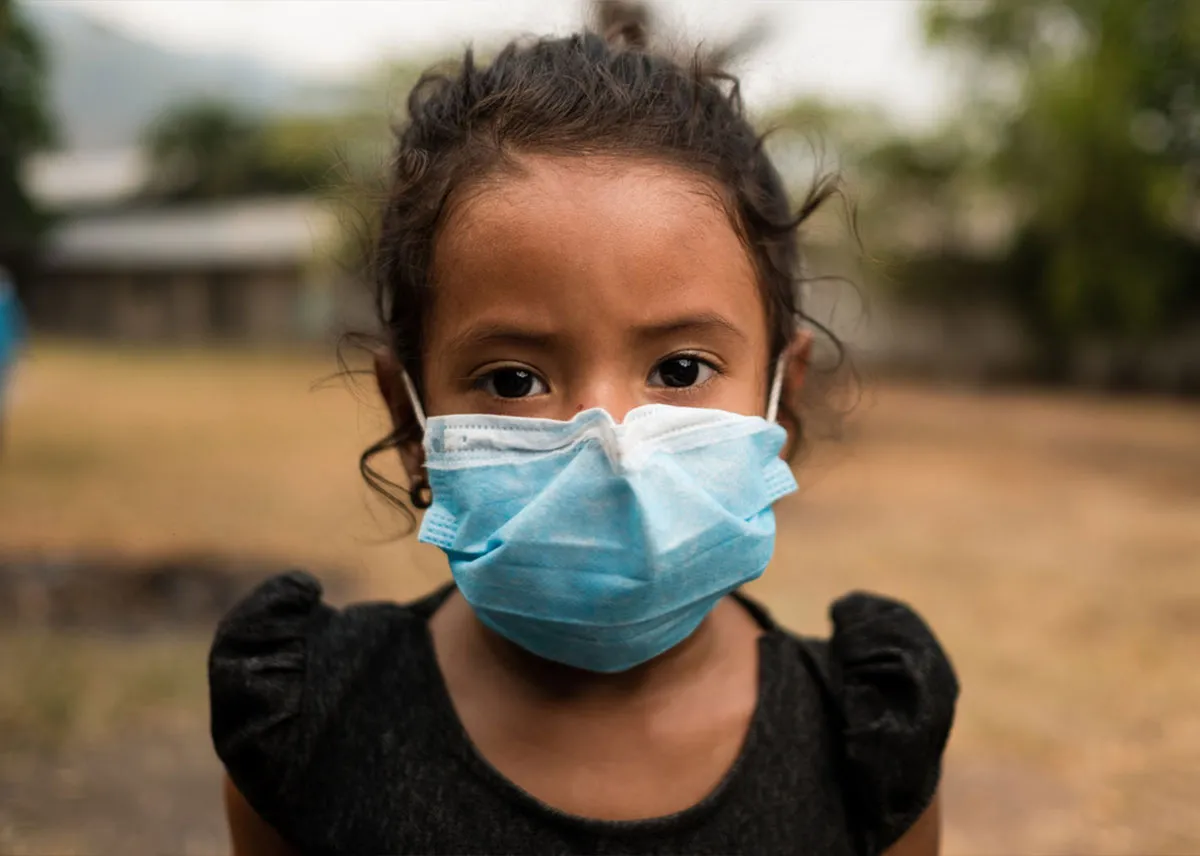 A young girl wearing a light blue face mask.