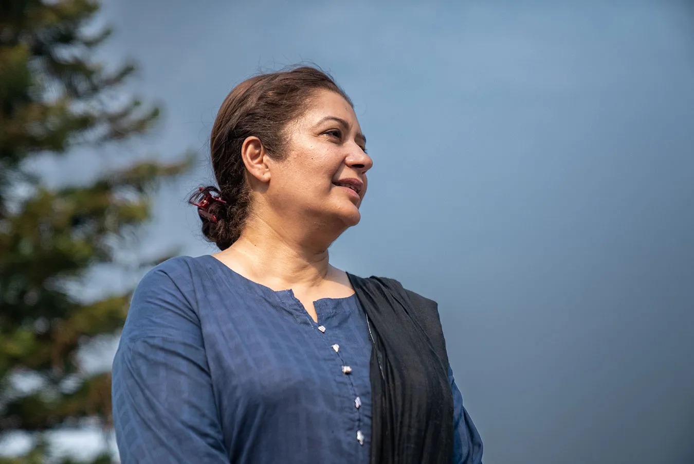 A profile shot of a Pakistani woman in front of a blue sky.